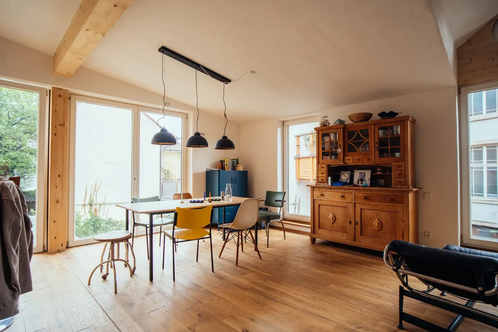 Heller Wohnraum mit sichtbaren Holzbalken und Holzboden